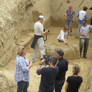 Team of anthropology students and locals digging in a big hole