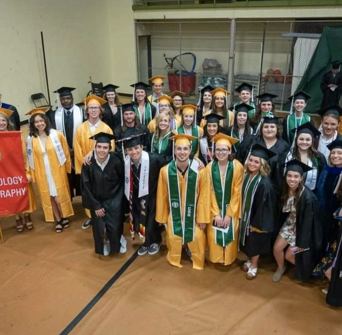 Student group in caps and gowns inside arena