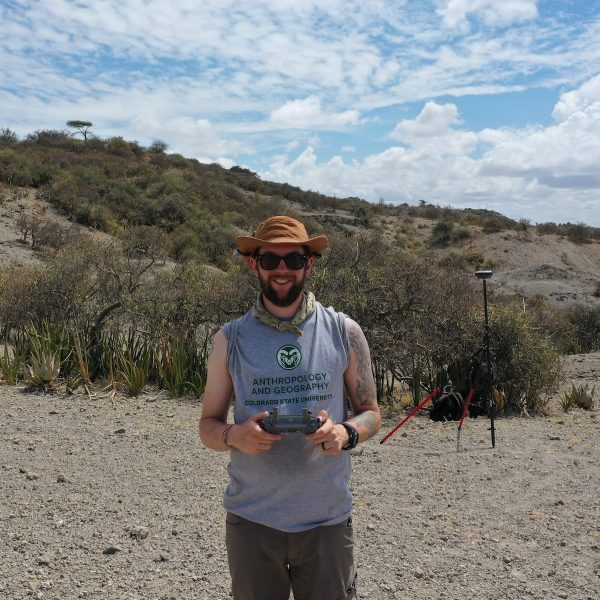 Man holding a drone remote control standing in gorge in Tanzania