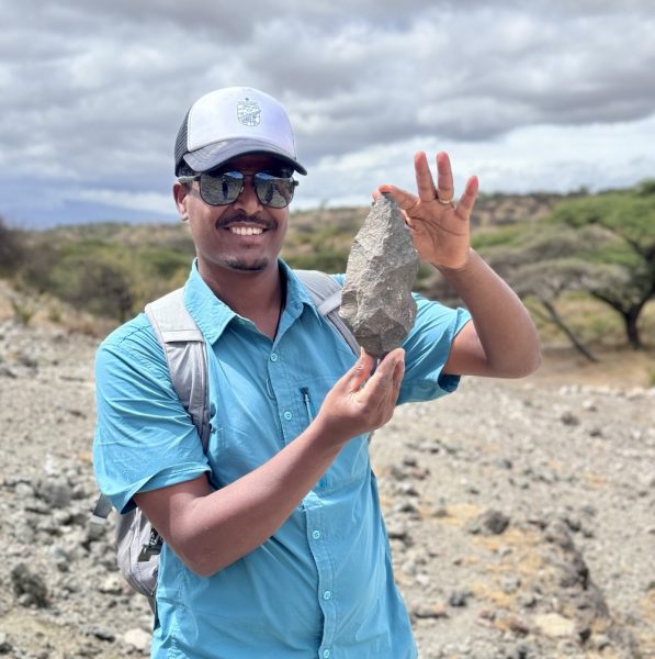 Man holding large one-million-year-old stone handaxe.