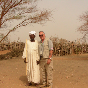 Man in a rober and man in field clothes stand outside in Sudan