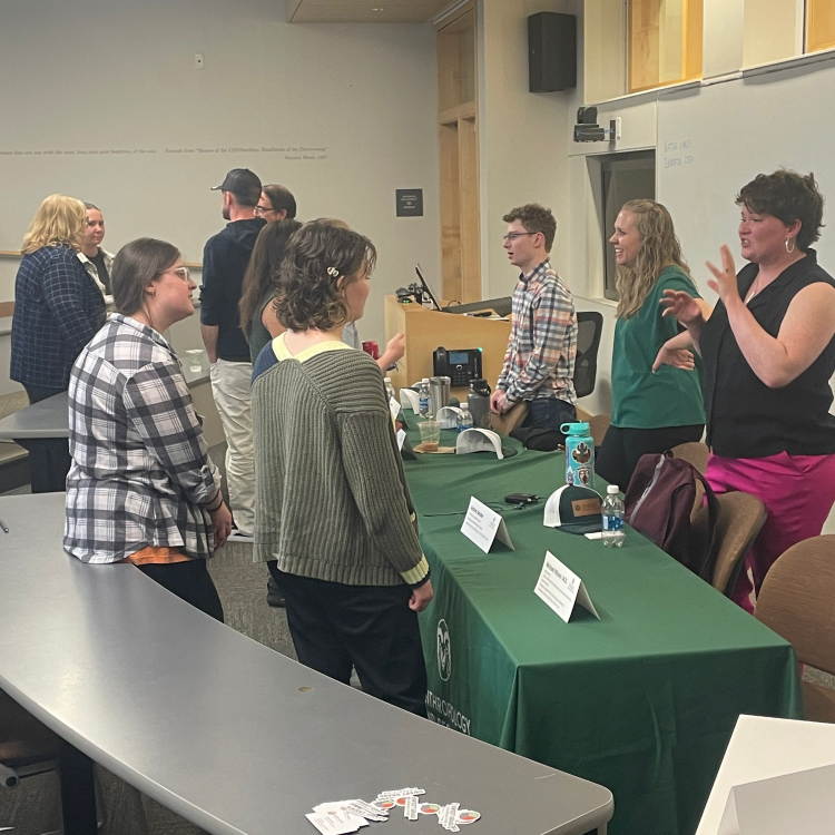 Students and alumni talking inside a classroom