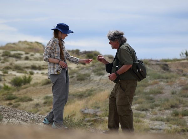 Student and instructor look at fossil in the field