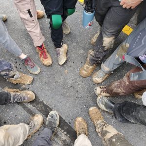 Circle of feet in muddy boots in a parking lot