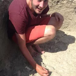 Anthropology student cutting into the dirt