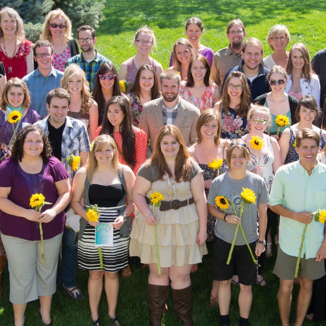 Anthropology graduates posing for photo holding sunflowers
