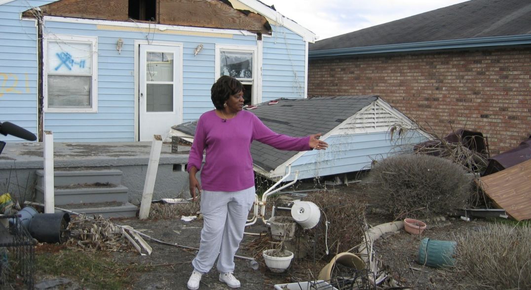Woman shows a destroyed home