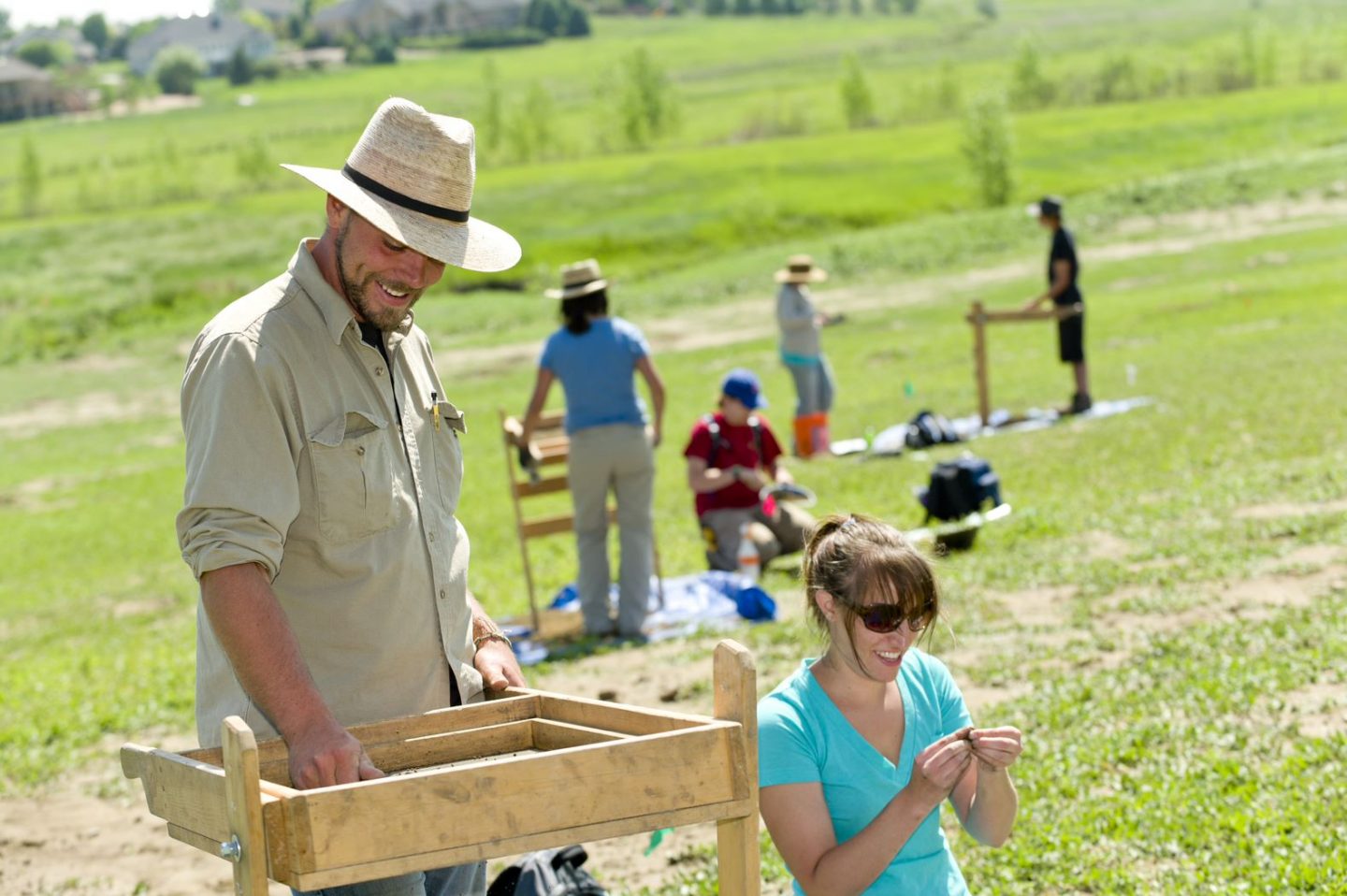 Students happily digging through dirt in Archaeology Field School