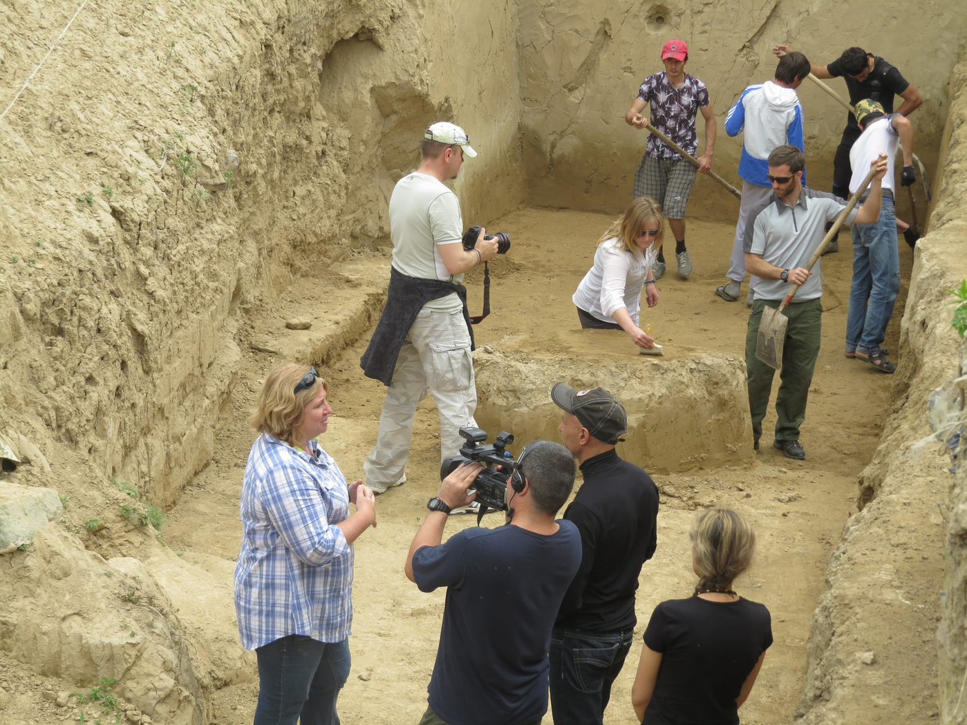 Team of anthropology students and locals digging in a big hole