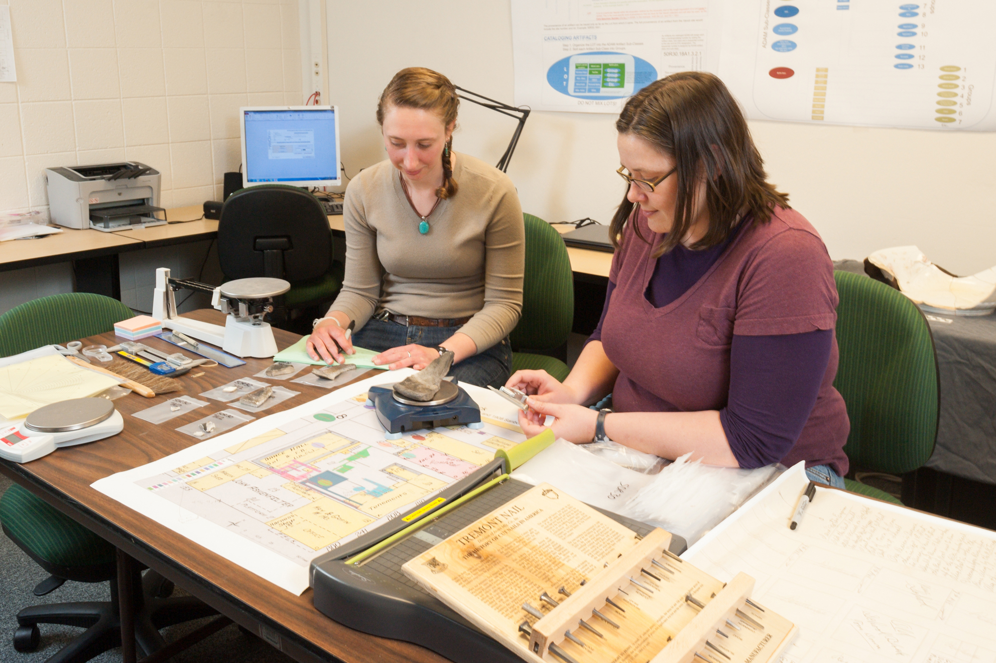 Colorado State University Archaeology graduate students Becca Simon and Kristi Gensmer measure specimens in the Historical Archaeological Laboratory.