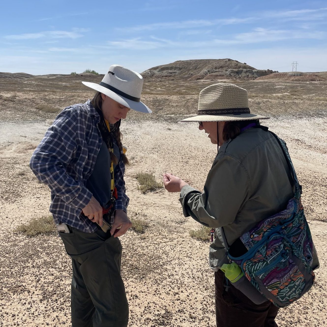Professor and student look at collected fossils