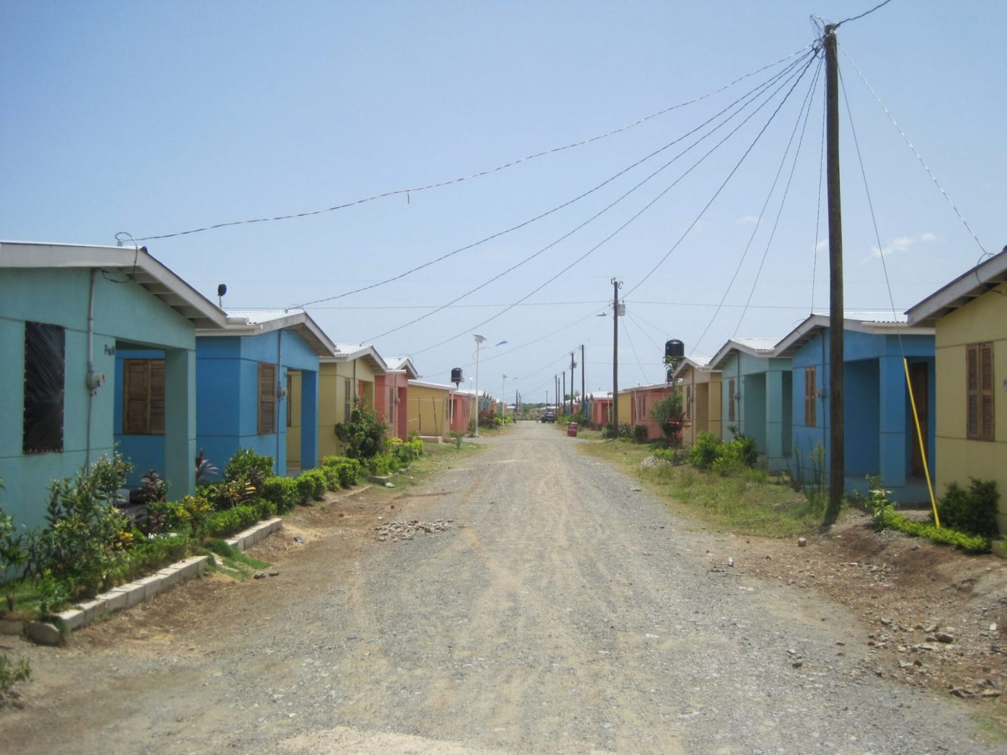 a road with small houses on each side in a rural area in Haiti
